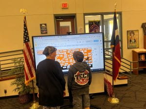 Photo of student and teacher in front of the interactive flat panel.